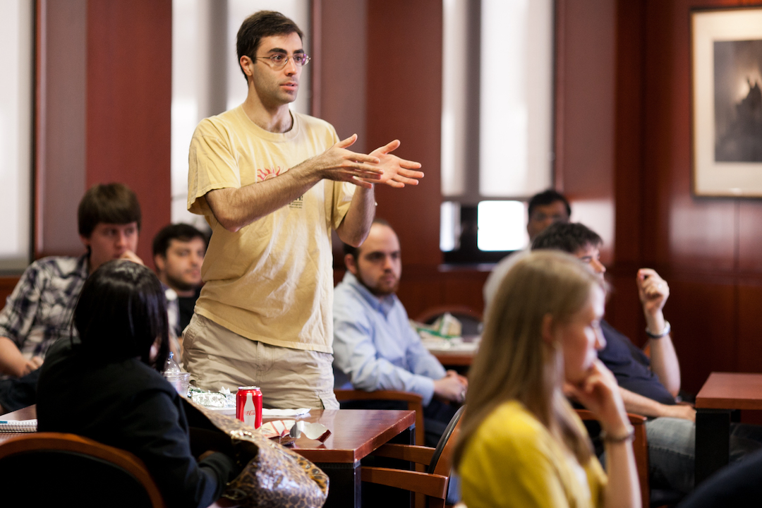 A student standing and asking a question in a lecture event
