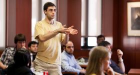 A student standing and asking a question in a lecture event
